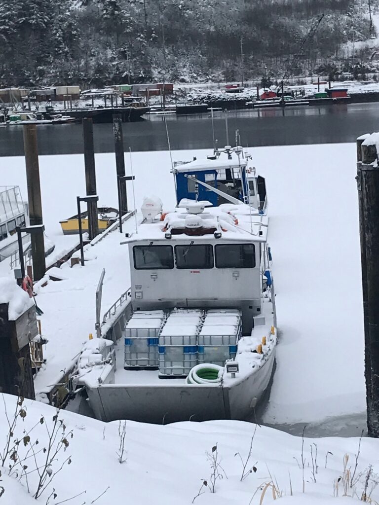 A loaded Remote Made Easy boat docked with snow and ice around the landscape.