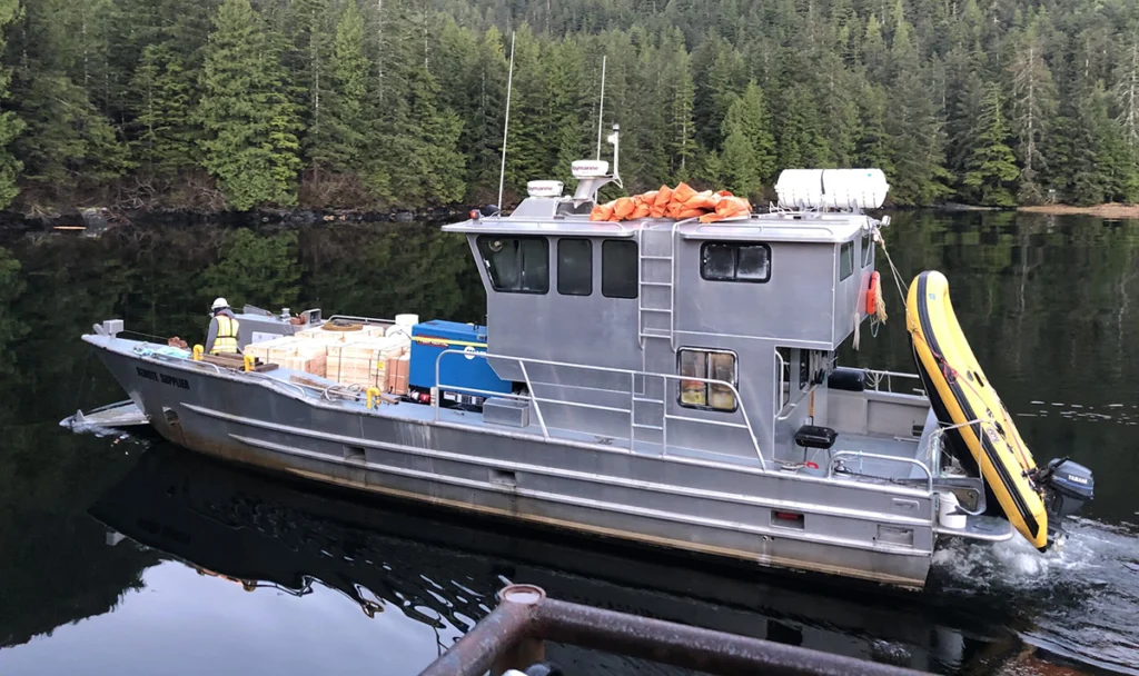A Remote Made Easy boat Leaving the dock to deliver a shipment of wood and supplies.
